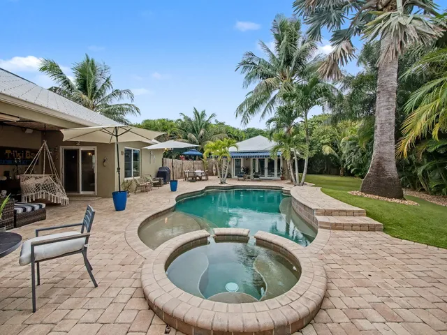 a view of a house with swimming pool and sitting area