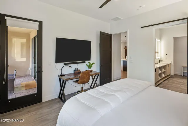 a bedroom with a bed and a flat tv screen on wall