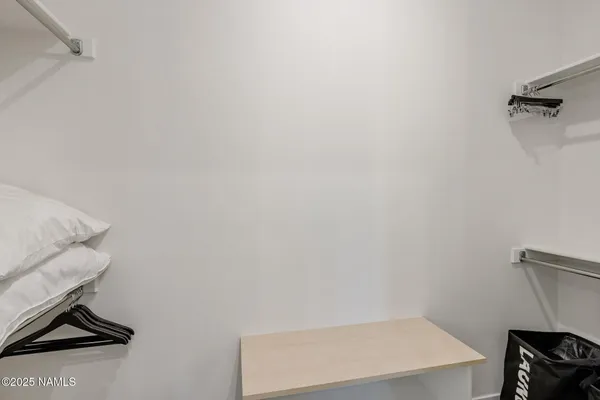 a view of walk in closet with empty racks