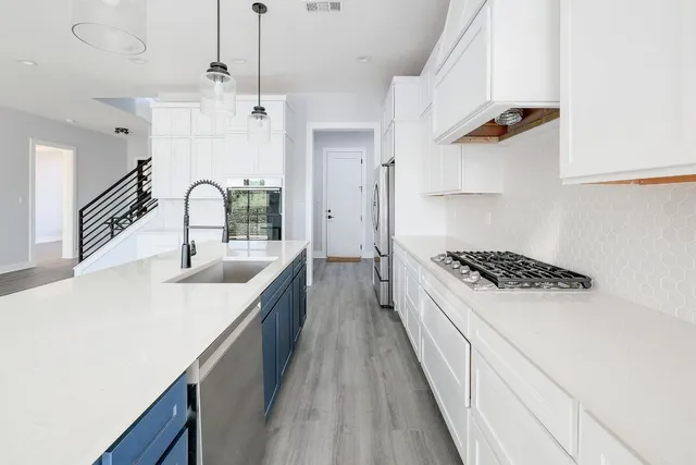 a kitchen with kitchen island a sink stove and refrigerator