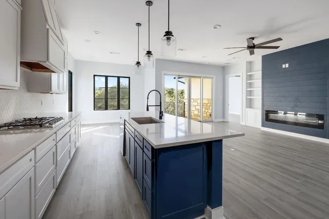 a kitchen with stainless steel appliances granite countertop a kitchen island a stove a sink and a refrigerator