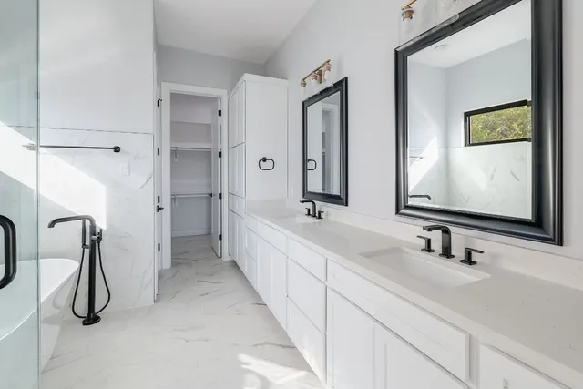 a bathroom with a double vanity sink mirror and shower