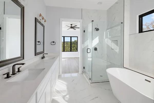 a large spacious bathroom with a tub shower and mirror