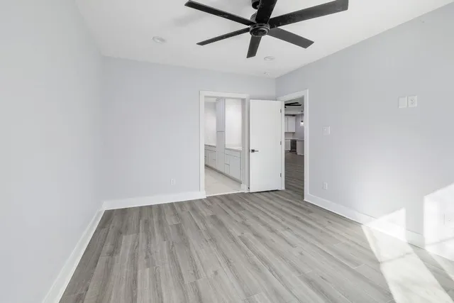 an empty room with closet and a ceiling fan