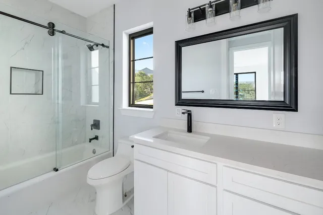 a bathroom with a sink a toilet and shower