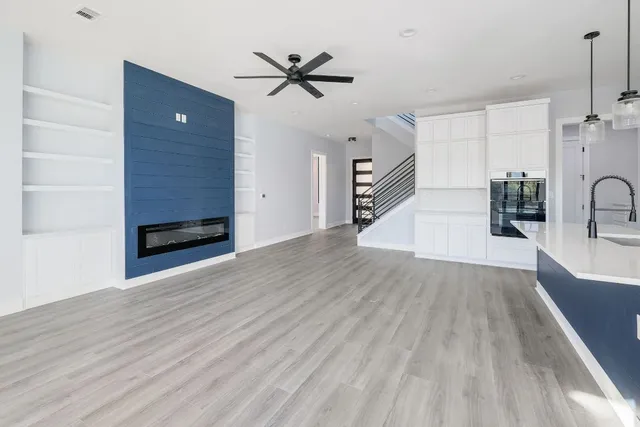 a view of a living room a ceiling fan and wooden floor