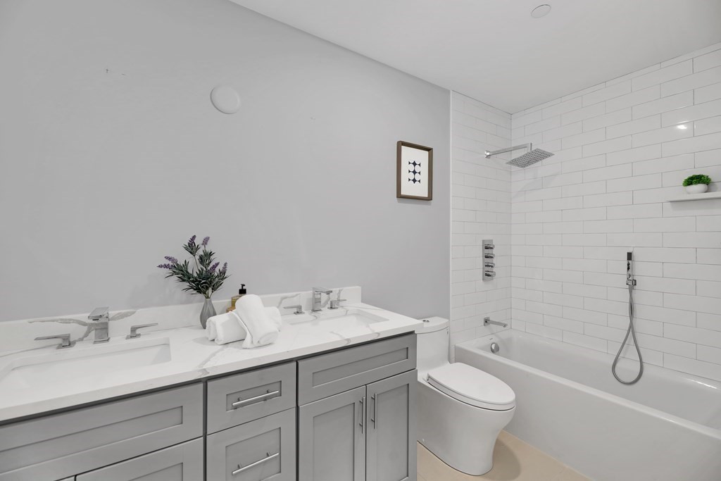 480 West Broadway, Unit 103 Boston, MA 02127 - Photo 14 of 19 a bathroom with a granite countertop toilet a sink and a bathtub