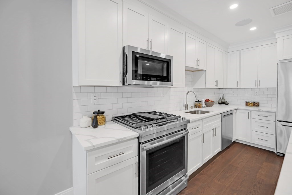 480 West Broadway, Unit 103 Boston, MA 02127 - Photo 6 of 19 a kitchen with cabinets stainless steel appliances and sink