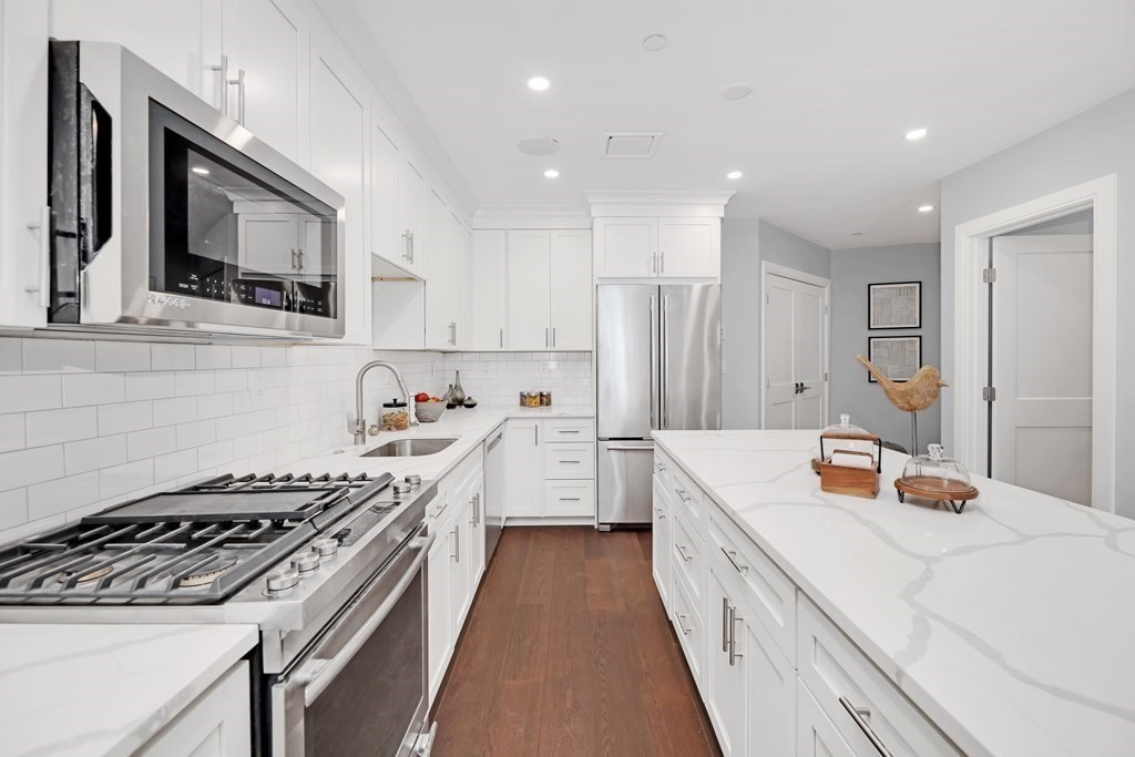 480 West Broadway, Unit 103 Boston, MA 02127 - Photo 7 of 19 a kitchen with a stove a sink and a microwave