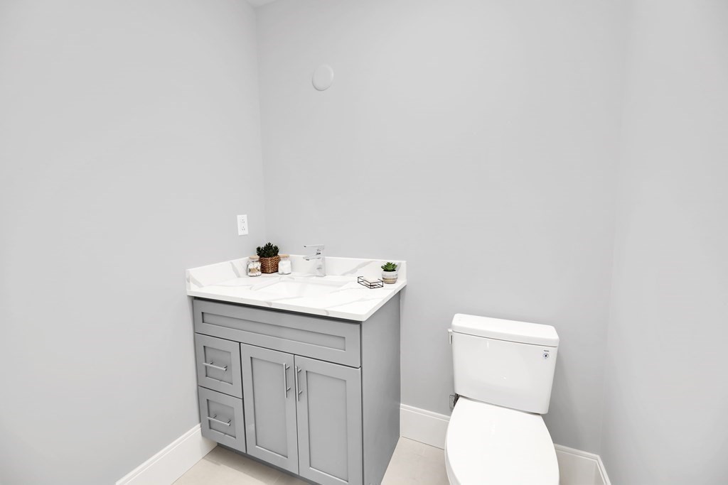 480 West Broadway, Unit 103 Boston, MA 02127 - Photo 9 of 19 a bathroom with a sink a toilet and a mirror