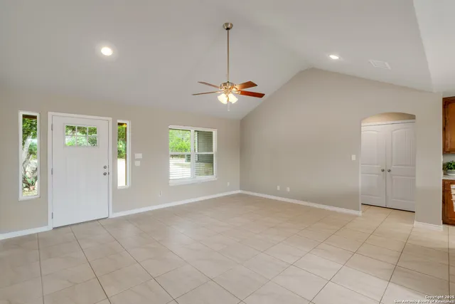 a bedroom with a large bed chandelier and a window
