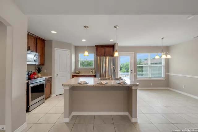 a kitchen with kitchen island a sink and a stove