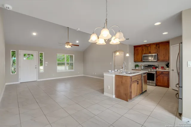 a large white kitchen with a large window appliances and cabinets