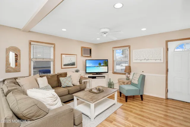 a living room with furniture a flat screen tv and a large window