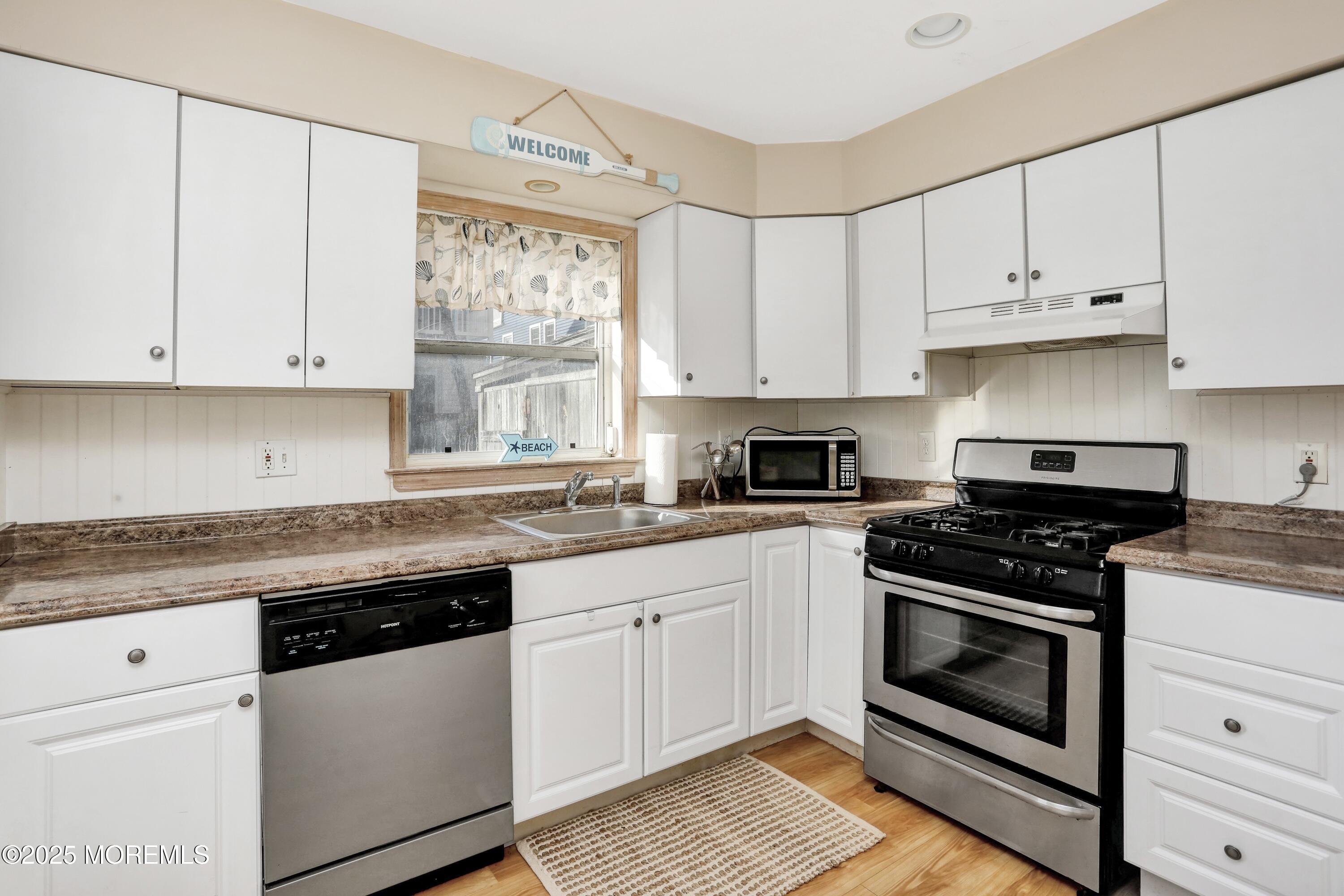 313 Shuster Avenue Seaside Heights, NJ 08751 - Photo 10 of 34 a kitchen with granite countertop white cabinets and white appliances