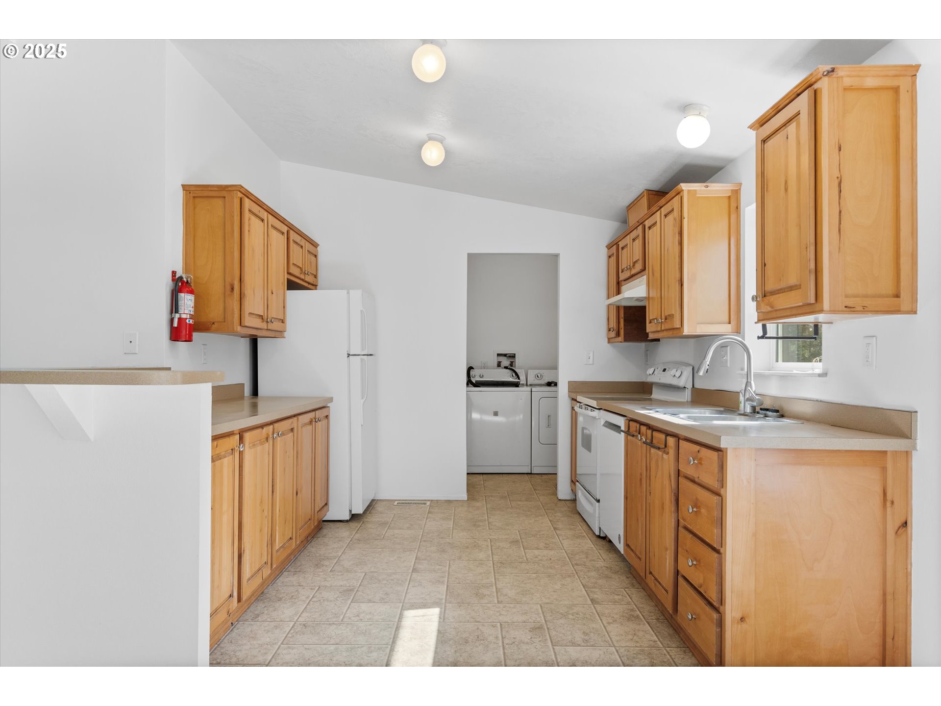 13996 Holcomb Boulevard Oregon City, OR 97045 - Photo 17 of 42 a kitchen with cabinets a sink a window and a refrigerator