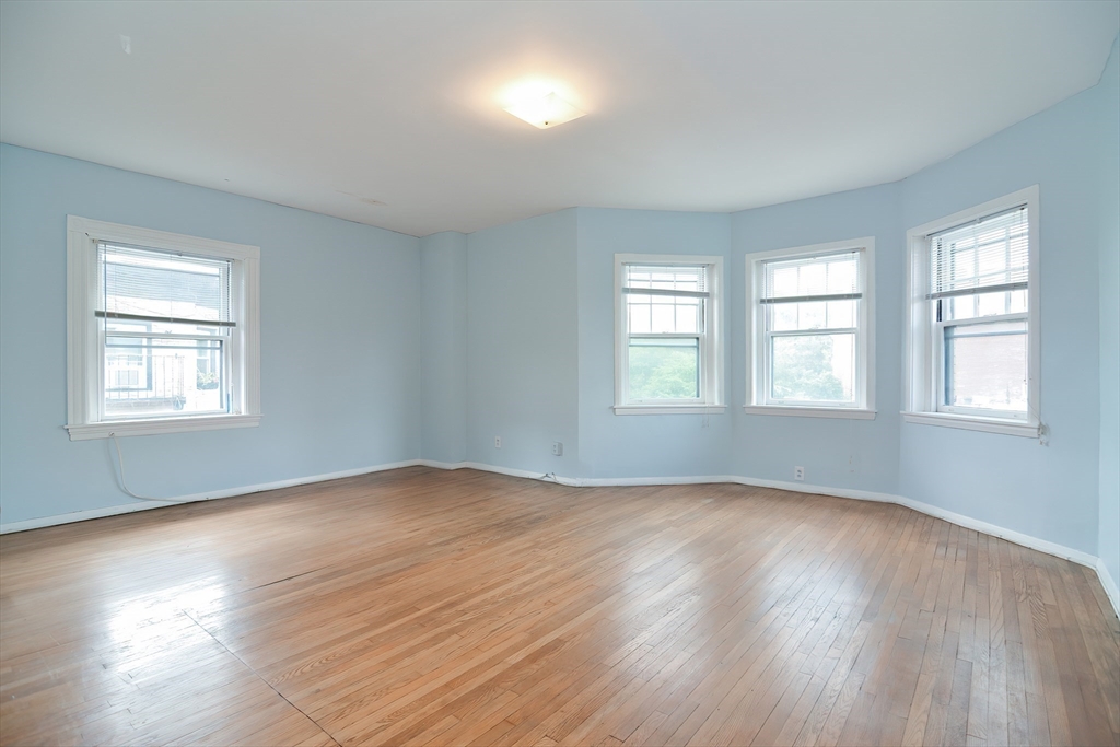 923 Beacon Street, Unit 2 Boston, MA 02215 - Photo 5 of 11 a view of an empty room with wooden floor and a window