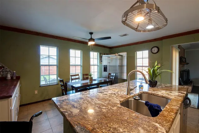 a large kitchen with sink a window and dining table