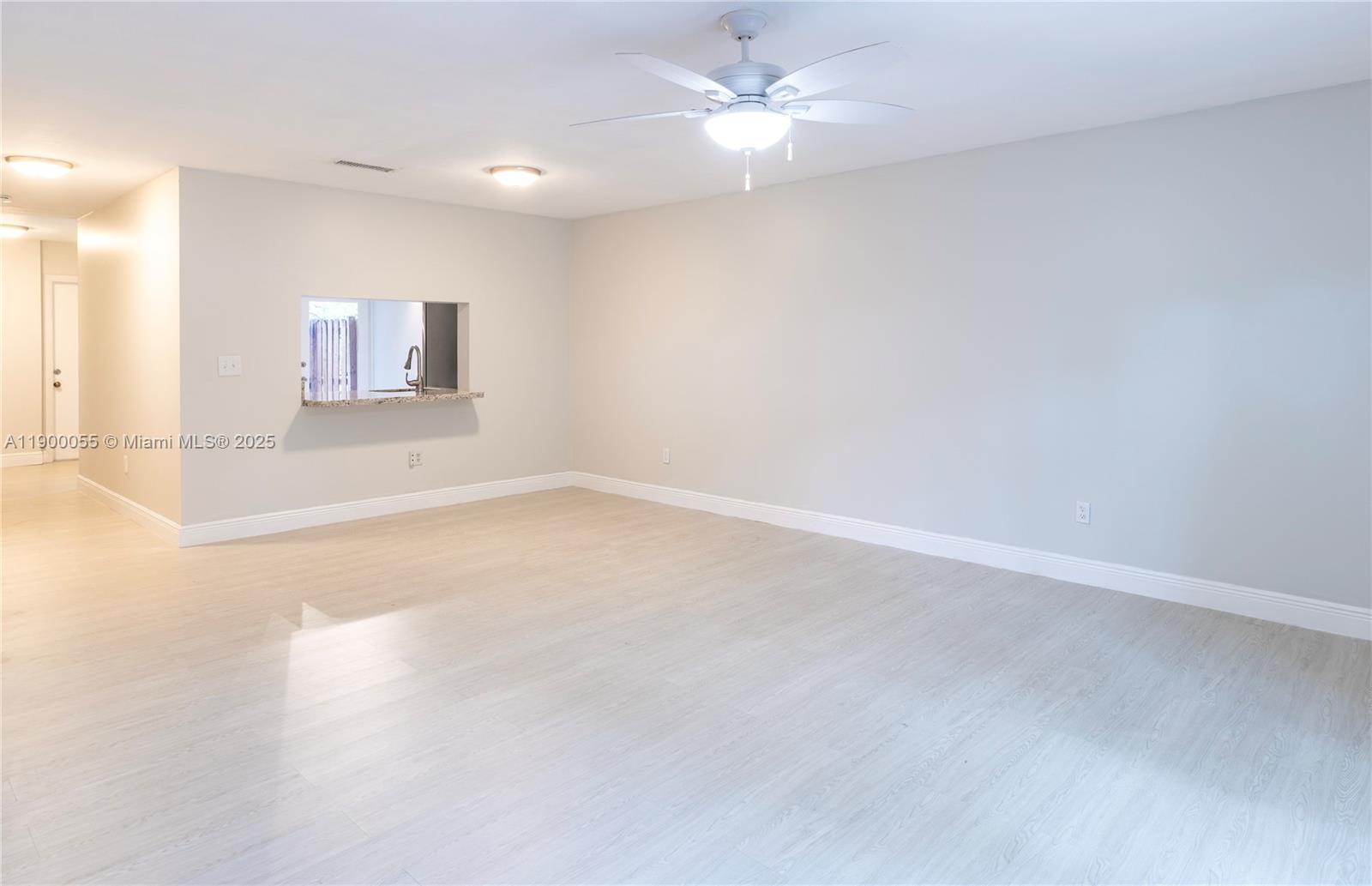 14237 Southwest 94th Cir Lane, Unit 101 Miami, FL 33186 - Photo 11 of 34 an empty room with a ceiling fan and a window