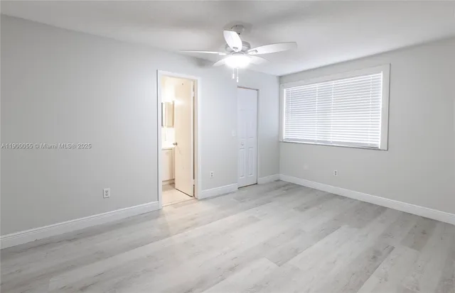 an empty room with closet and a ceiling fan