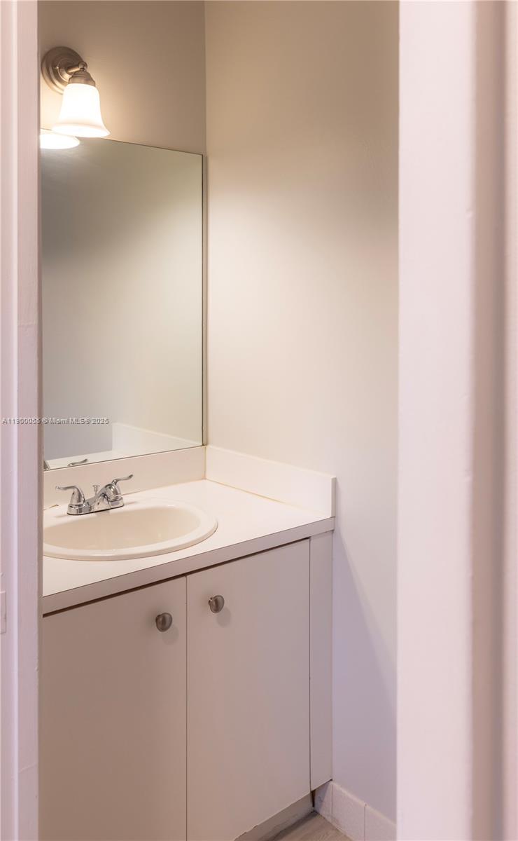 14237 Southwest 94th Cir Lane, Unit 101 Miami, FL 33186 - Photo 6 of 34 a bathroom with a sink and a mirror
