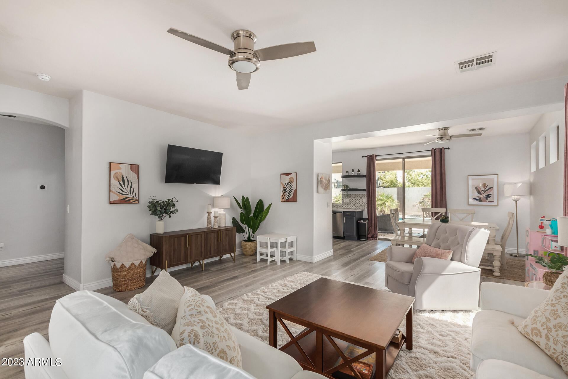 17560 West E Wind Avenue Goodyear, AZ 85338 - Photo 3 of 30 a living room with furniture a dining table and a potted plant