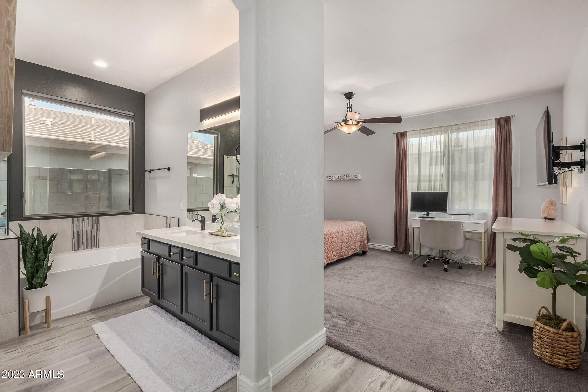 17560 West E Wind Avenue Goodyear, AZ 85338 - Photo 10 of 30 a spacious en suite bathroom with a tub double vanity and mirror