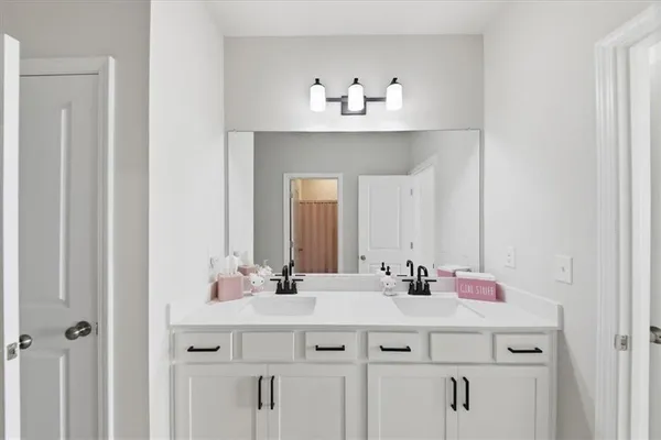 a bathroom with double vanity sink and a mirror