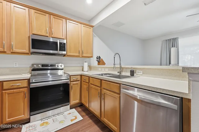 a kitchen with stainless steel appliances granite countertop a sink stove and microwave
