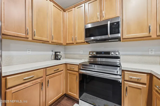 a kitchen with stainless steel appliances granite countertop a stove microwave and cabinets