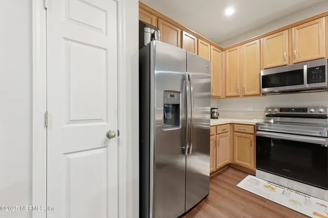 a kitchen with stainless steel appliances granite countertop a refrigerator a stove a microwave oven with cabinets