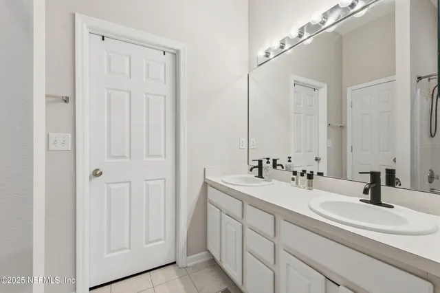 a bathroom with double vanity sink and a mirror