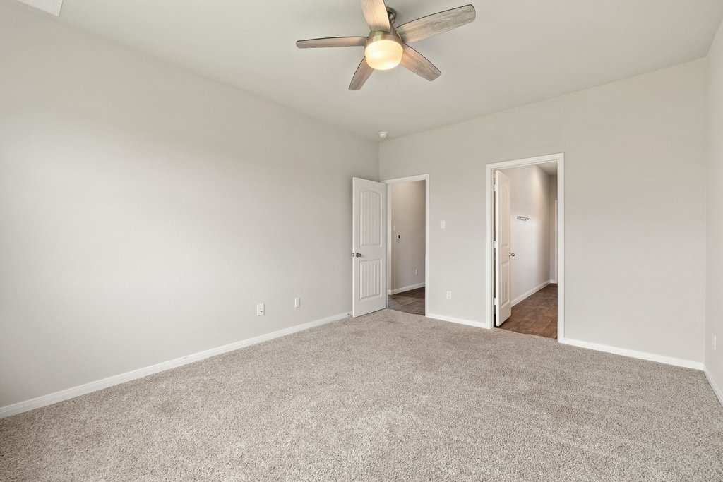 102 Ashford Way Georgetown, TX 78626 - Photo 13 of 28 A neutrally painted bedroom offers comfort with soft carpeting and a ceiling fan for climate control.