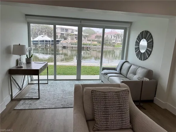 a living room with furniture and a floor to ceiling window