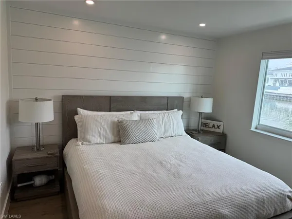 a large bed sitting in a bedroom next to a window