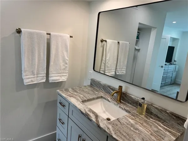 a bathroom with a granite countertop sink and a mirror