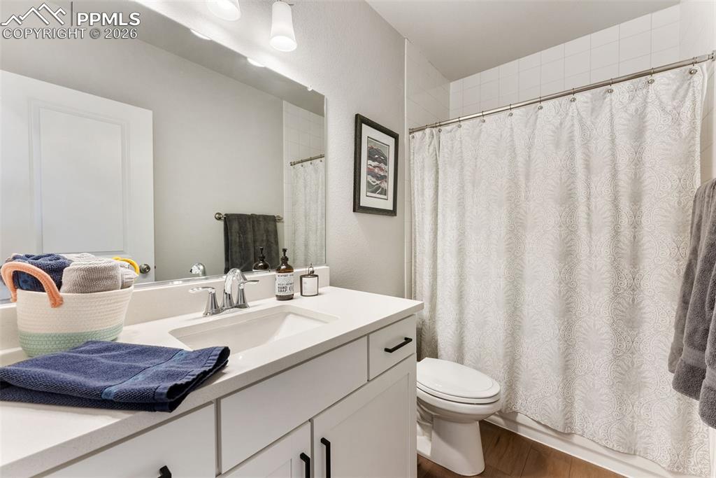 10484 Wrangell Circle Colorado Springs, CO 80924 - Photo 26 of 50 a bathroom with a sink a toilet and shower curtain
