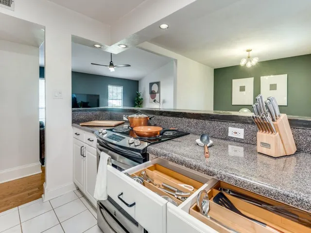 a kitchen with stainless steel appliances granite countertop a sink and a stove