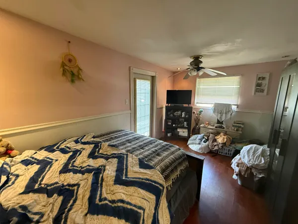 a bedroom with a bed and wooden floor