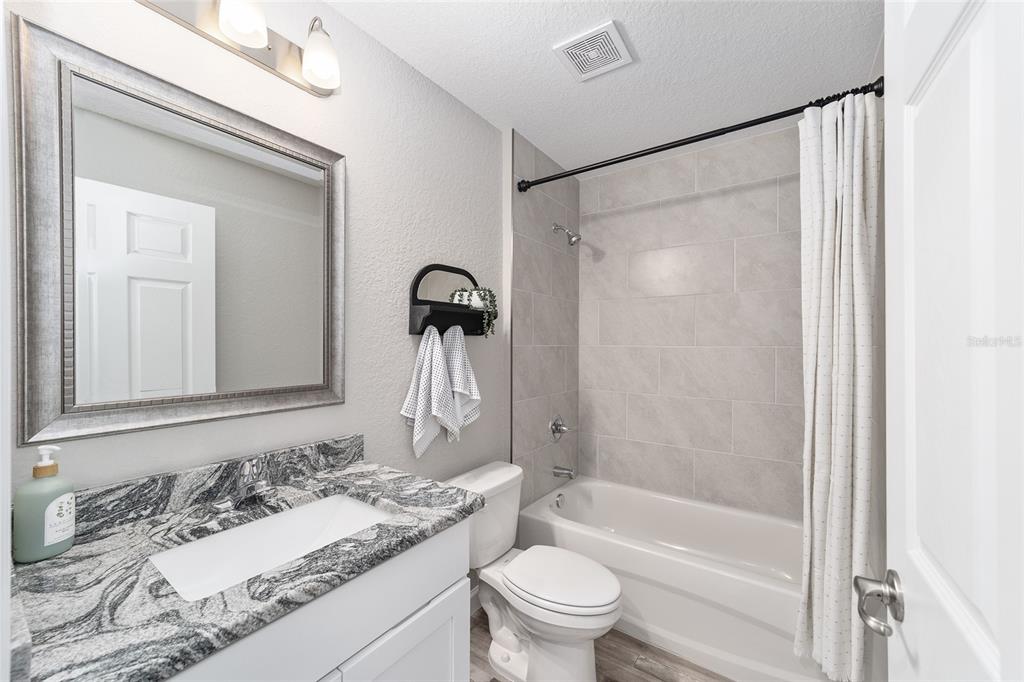 8571 Southwest 131st Place Ocala, FL 34473 - Photo 26 of 32 a bathroom with a granite countertop sink toilet and shower