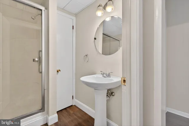 a bathroom with a sink a mirror and shower view