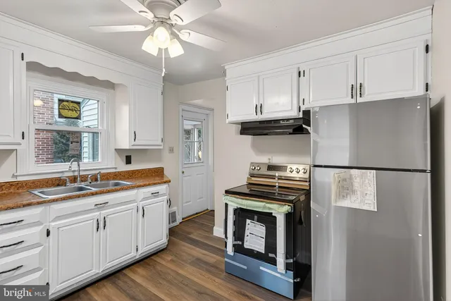 a kitchen with a stove white refrigerator sink and dishwasher with wooden floor