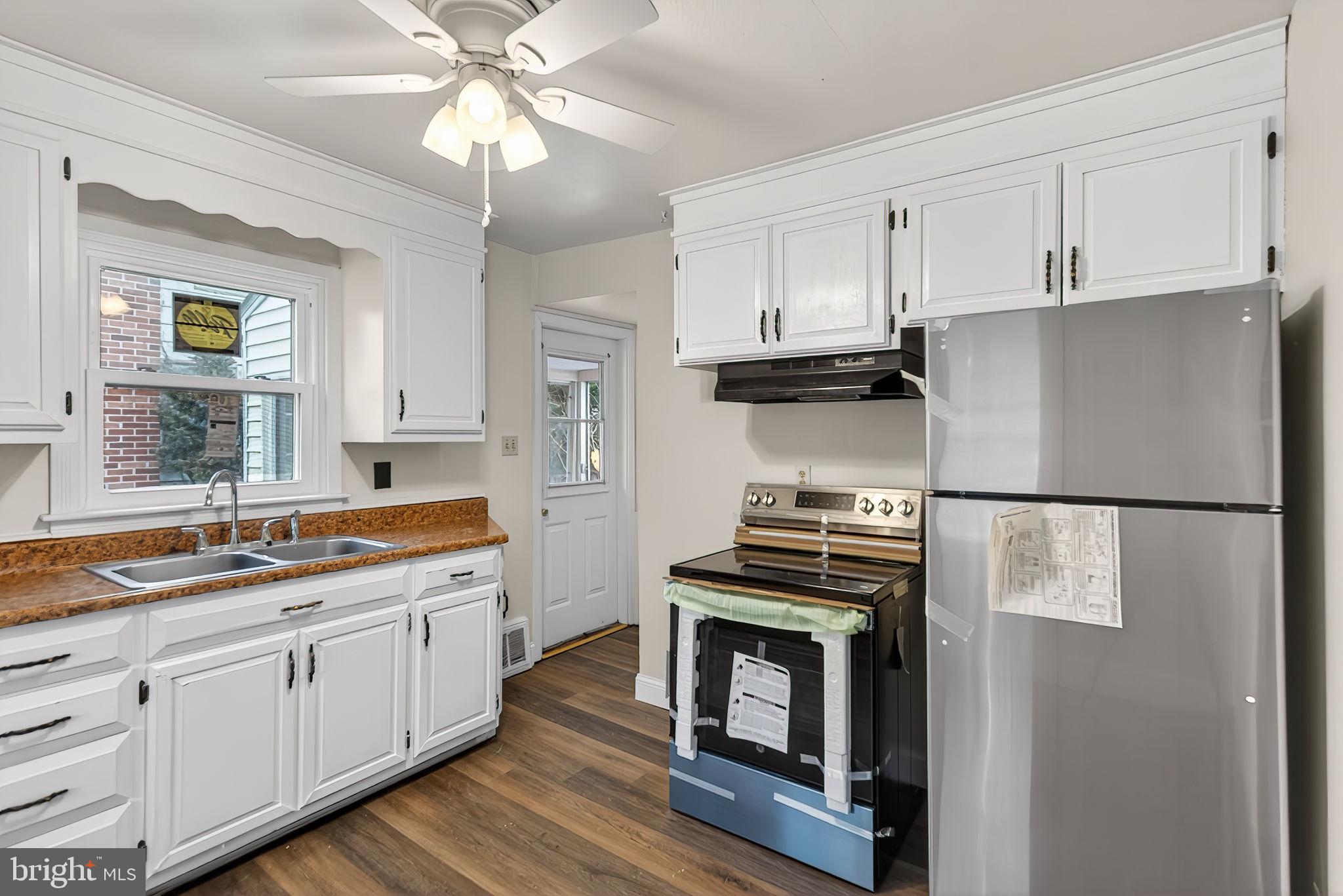 2527 North George Street York, PA 17406 - Photo 3 of 24 a kitchen with a stove white refrigerator sink and dishwasher with wooden floor