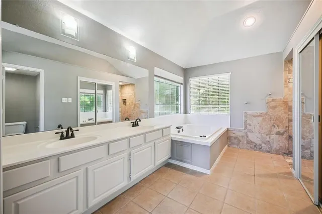 a spacious bathroom with a double vanity sink a large mirror and shower