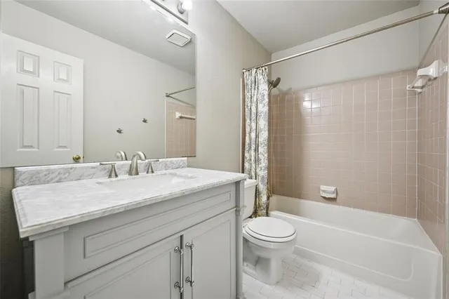 a bathroom with a granite countertop sink a toilet and shower