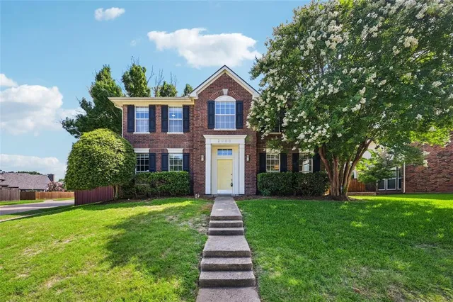 a front view of a house with yard and green space