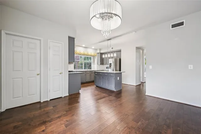 a view of a kitchen with a sink dishwasher and a refrigerator with wooden floor