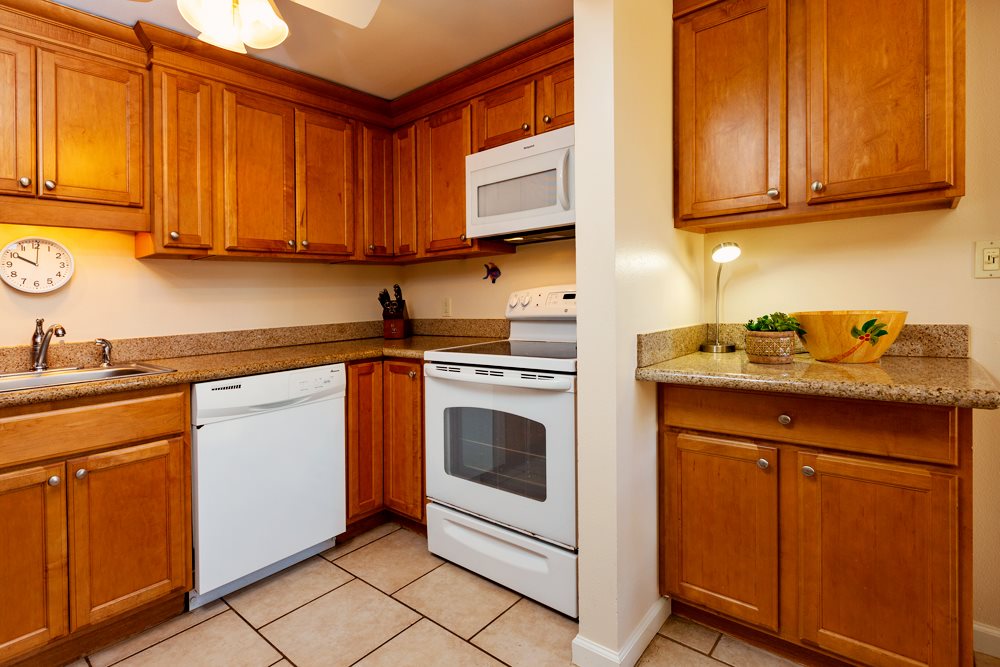 115 North Kihei Road, Unit B1 Kihei, HI 96753 - Photo 8 of 29 a kitchen with stainless steel appliances granite countertop a sink stove and cabinets