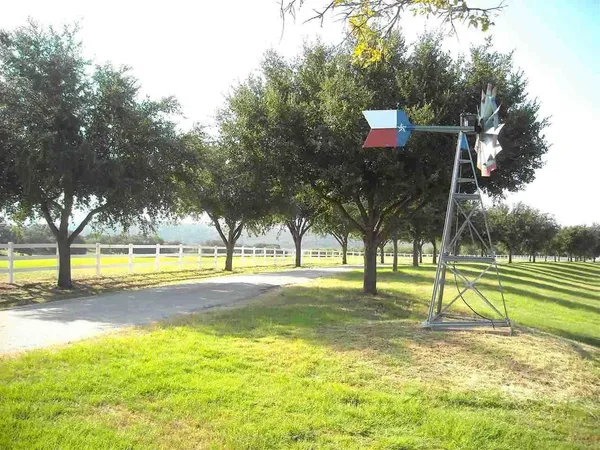a view of swimming pool with trees and a small yard