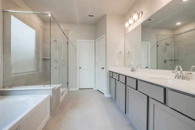 a bathroom with a double vanity sink mirror double and shower